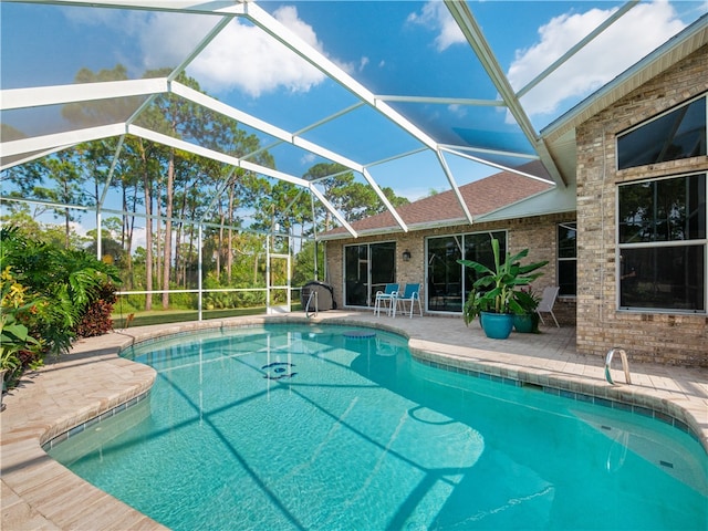 view of pool featuring glass enclosure and a patio area