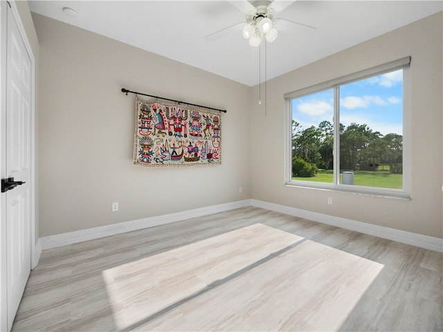 empty room with ceiling fan and light hardwood / wood-style flooring