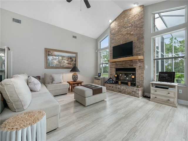 living room with a fireplace, plenty of natural light, and light wood-type flooring