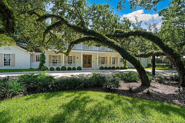 view of front of property with a front yard and a balcony