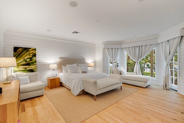 bedroom featuring access to exterior, hardwood / wood-style floors, and ornamental molding