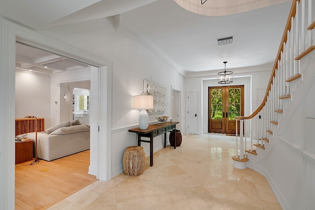 foyer featuring ornamental molding, beam ceiling, a chandelier, light hardwood / wood-style flooring, and coffered ceiling