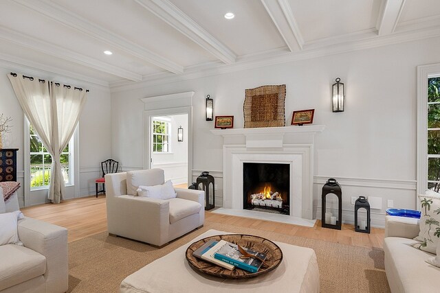 living room with beam ceiling, hardwood / wood-style flooring, and plenty of natural light