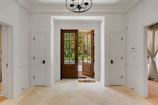 entryway featuring a notable chandelier and crown molding