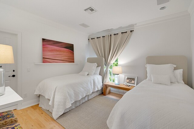 bedroom with ornamental molding and hardwood / wood-style floors