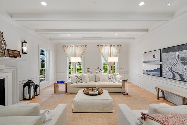 living room featuring light hardwood / wood-style floors, crown molding, and beam ceiling