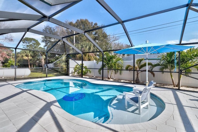 view of pool featuring glass enclosure and a patio