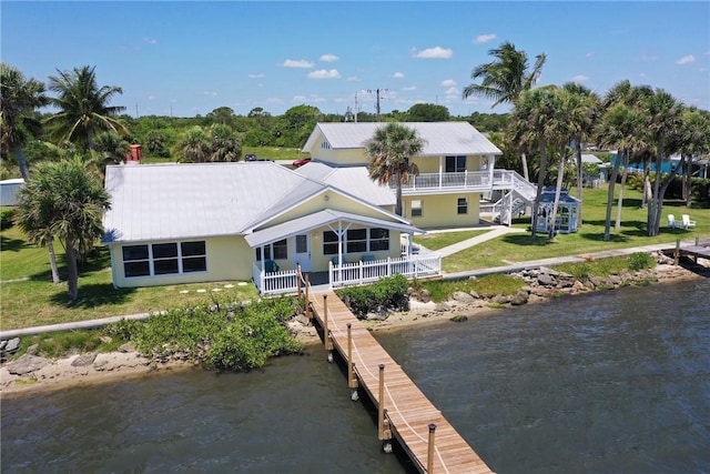 back of house featuring a yard and a water view