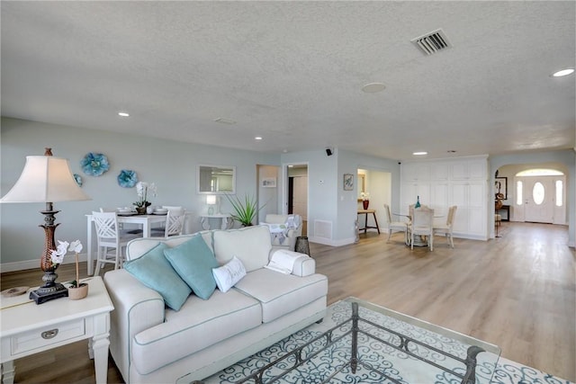 living room with light hardwood / wood-style floors and a textured ceiling