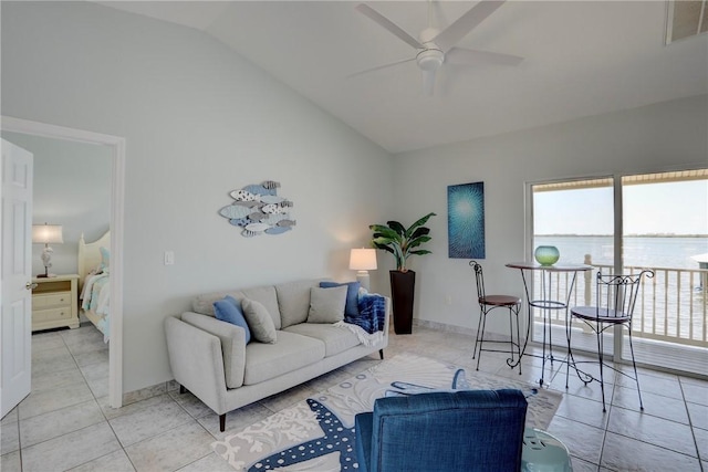 tiled living room with a water view, ceiling fan, and lofted ceiling