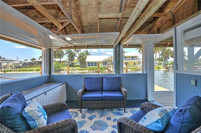 sunroom with plenty of natural light and a water view