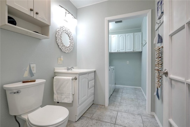 bathroom featuring tile patterned floors, vanity, washer and dryer, and toilet