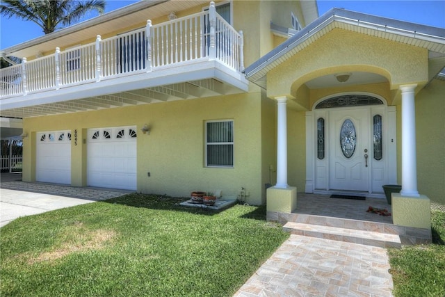 entrance to property featuring a lawn and a garage