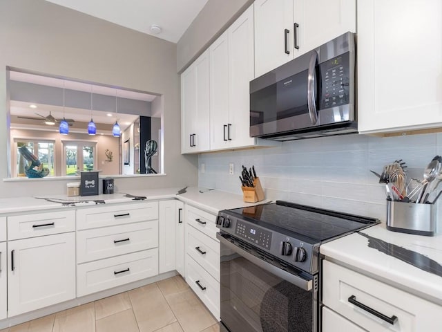 kitchen with white cabinetry, stainless steel microwave, light countertops, and electric stove