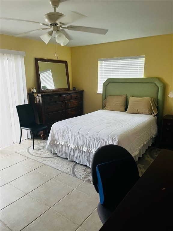 tiled bedroom featuring ceiling fan