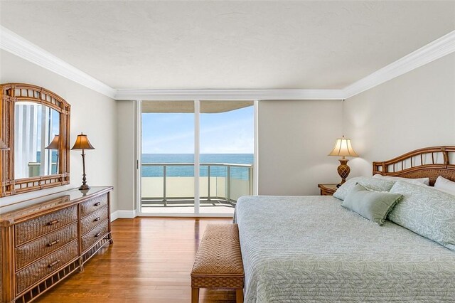 3554 S Ocean Dr Unit 1203, Vero Beach, FL 32963 - bedroom featuring dark wood-style floors, access to exterior, crown molding, expansive windows, and a water view