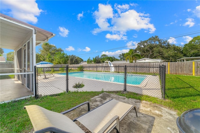 view of swimming pool with a patio, a sunroom, and a yard