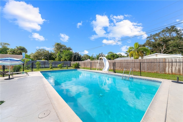 view of swimming pool with a water slide and a patio area