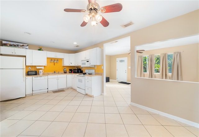 kitchen with tasteful backsplash, light tile patterned flooring, white cabinetry, white appliances, and ceiling fan