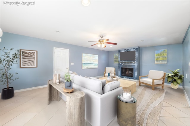 tiled living room with a fireplace and ceiling fan