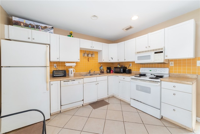 kitchen featuring sink, tasteful backsplash, light tile patterned floors, white appliances, and white cabinets