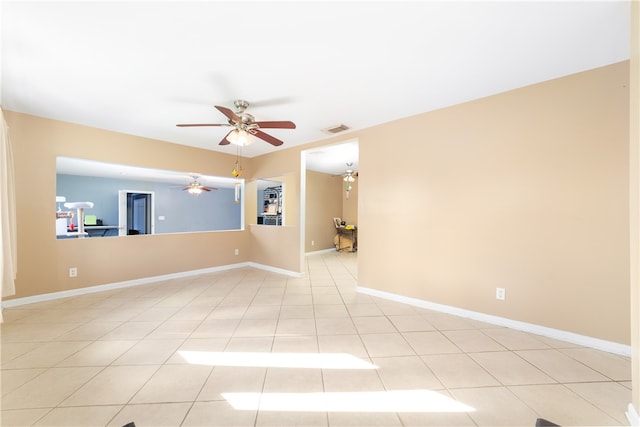 tiled spare room featuring ceiling fan