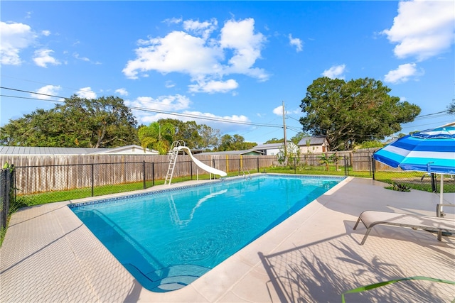 view of pool with a water slide and a patio area