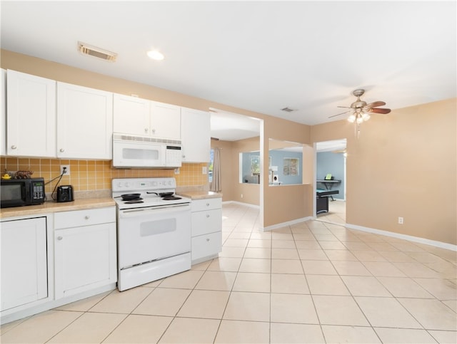 kitchen with light tile patterned flooring, tasteful backsplash, ceiling fan, white appliances, and white cabinets