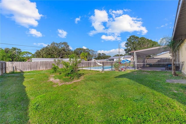 view of yard with a fenced in pool, glass enclosure, and a sunroom