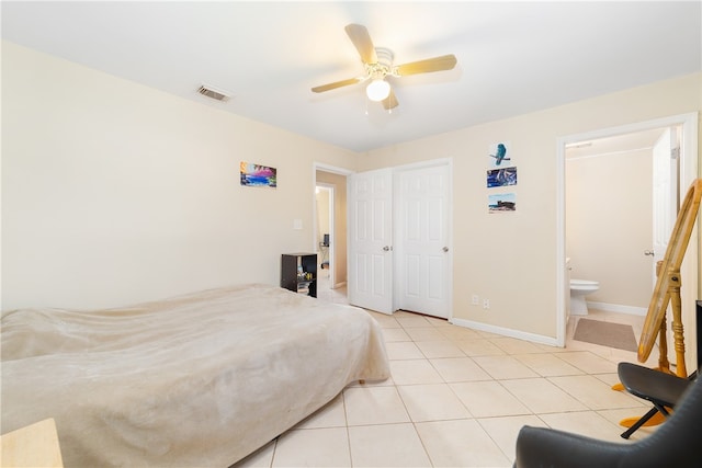 tiled bedroom with ceiling fan and ensuite bath