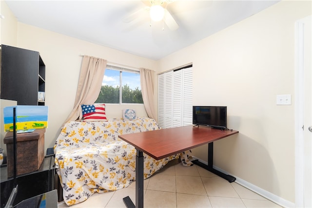 bedroom with light tile patterned floors, ceiling fan, and a closet