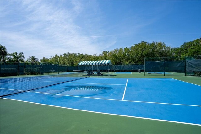 view of tennis court featuring fence