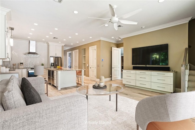 living room featuring recessed lighting, light wood-style flooring, and ornamental molding