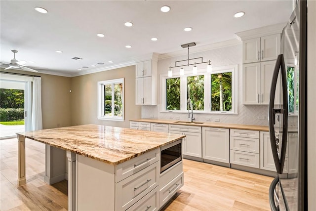 kitchen featuring ornamental molding, tasteful backsplash, appliances with stainless steel finishes, and a sink