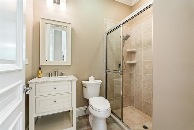 full bathroom featuring vanity, a shower stall, toilet, and baseboards