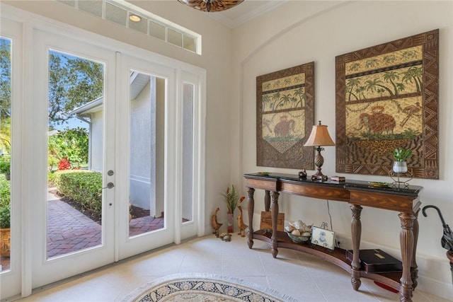 entryway featuring french doors, crown molding, and light tile patterned floors