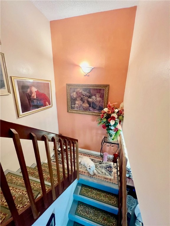 stairs featuring a textured ceiling