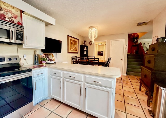 kitchen featuring white cabinetry, kitchen peninsula, and appliances with stainless steel finishes