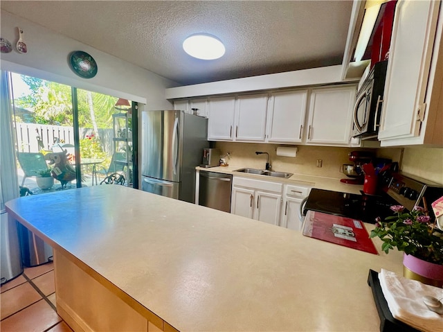 kitchen with sink, stainless steel appliances, white cabinets, and a textured ceiling