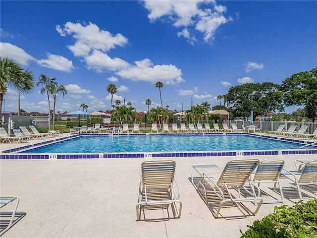 community pool with fence and a patio area
