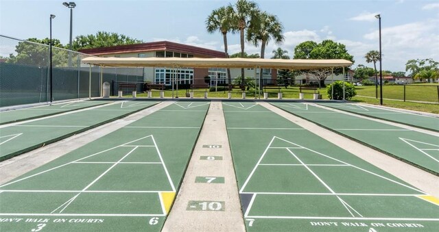 85 Crooked Tree Ln Unit 203, Vero Beach, FL 32962 - view of community featuring a lawn, fence, and shuffleboard