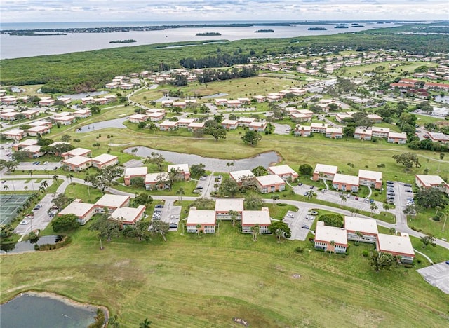 drone / aerial view with a water view, golf course view, and a residential view