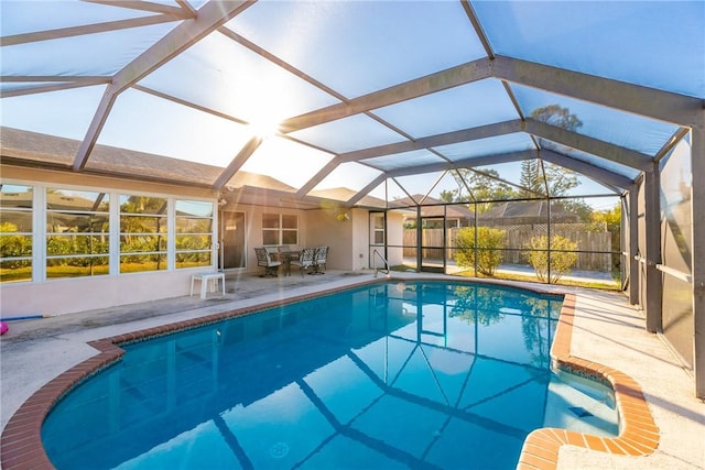 view of swimming pool featuring glass enclosure and a patio