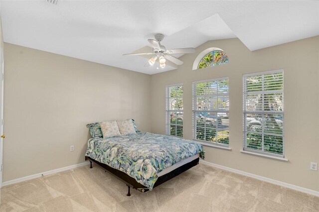 bedroom featuring light carpet, vaulted ceiling, and ceiling fan