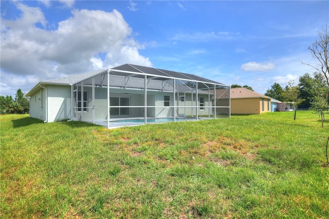 back of house with a yard and glass enclosure