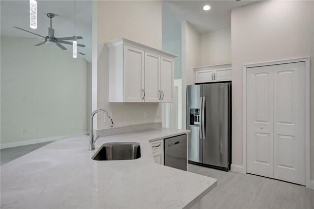 kitchen with white cabinets, light wood-type flooring, and stainless steel appliances