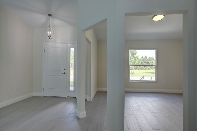 foyer entrance featuring light hardwood / wood-style floors and an inviting chandelier