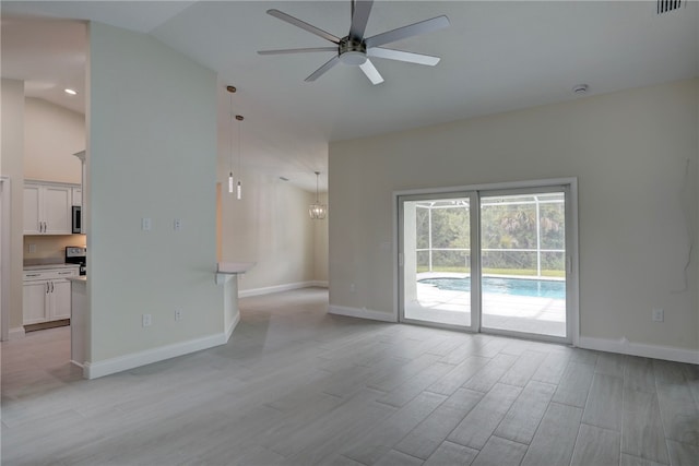 unfurnished living room with ceiling fan, vaulted ceiling, and light wood-type flooring