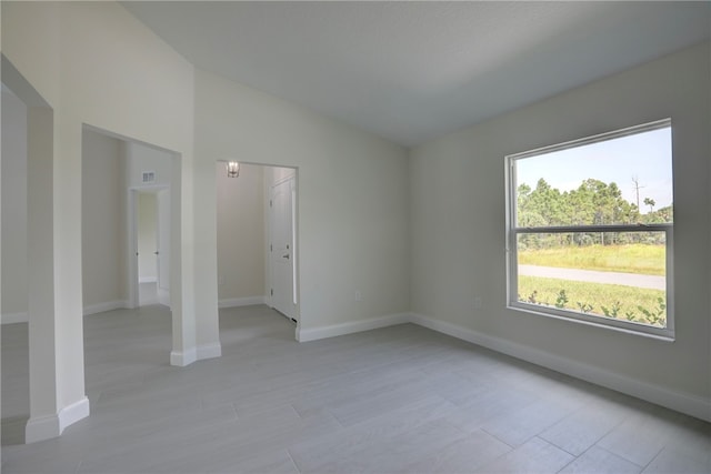 unfurnished room featuring vaulted ceiling