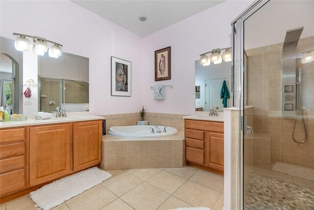 bathroom with tile patterned flooring, vanity, and separate shower and tub